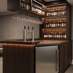 Finished basement home bar in a Kitchener house with a kegerator and taps, craft beer bottle display shelving, and organized glassware in warm lighting.